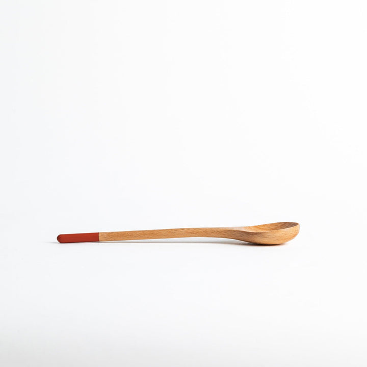 A set of four wooden soup spoons with wide, rounded bowls and colored tips—white, black, blue, and red.