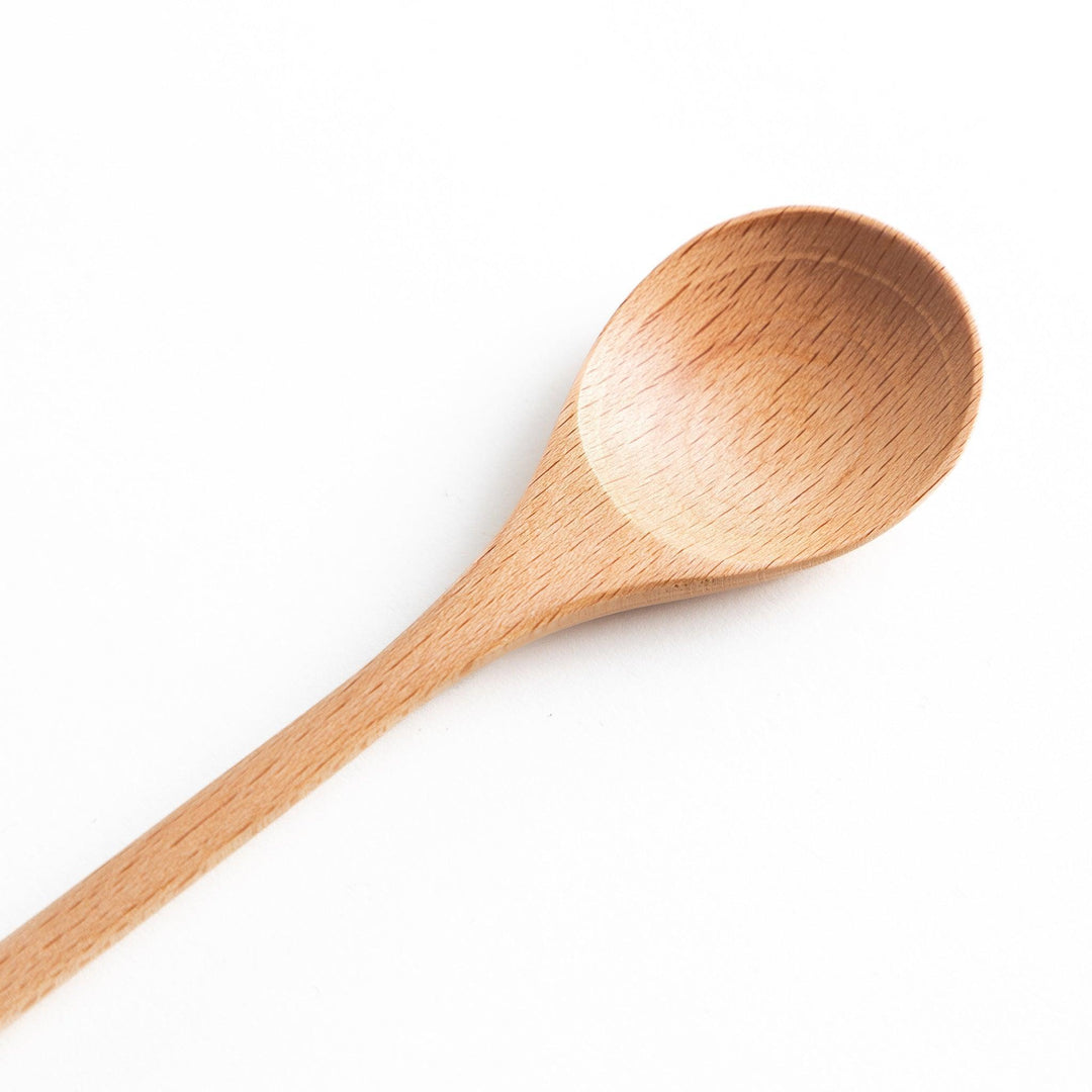 A set of four wooden soup spoons with wide, rounded bowls and colored tips—white, black, blue, and red.