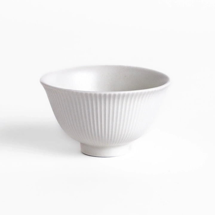 Ribbed white teacup with flared rim and smooth base offering simple elegance for everyday tea rituals.