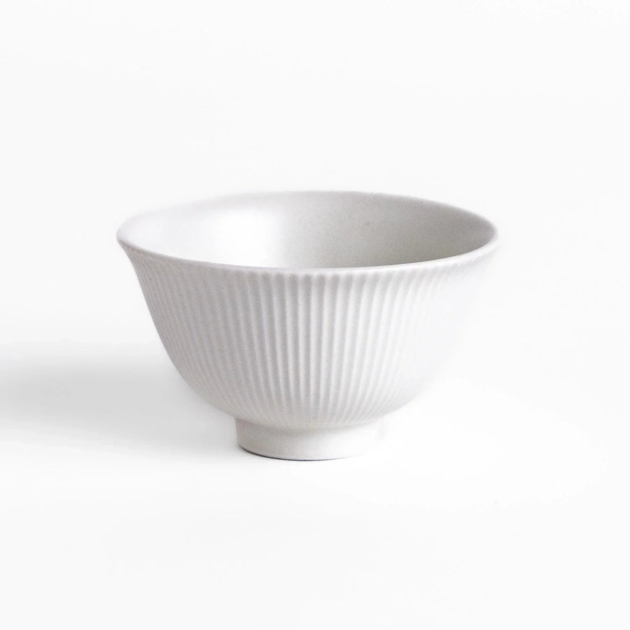 Ribbed white teacup with flared rim and smooth base offering simple elegance for everyday tea rituals.