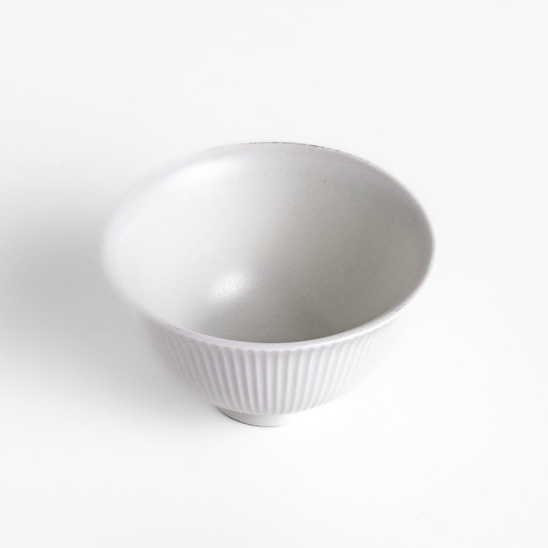 Ribbed white teacup with flared rim and smooth base offering simple elegance for everyday tea rituals.