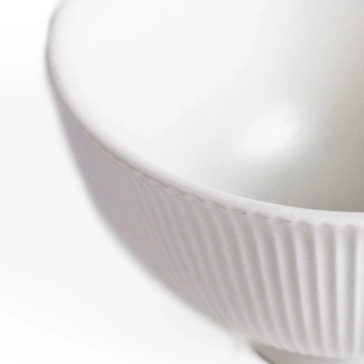 Ribbed white teacup with flared rim and smooth base offering simple elegance for everyday tea rituals.