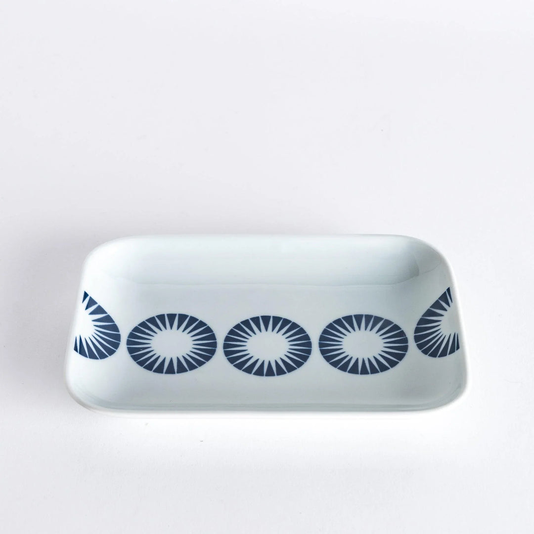 Side view of the dessert plate with the blue starburst circle pattern visible across the surface.