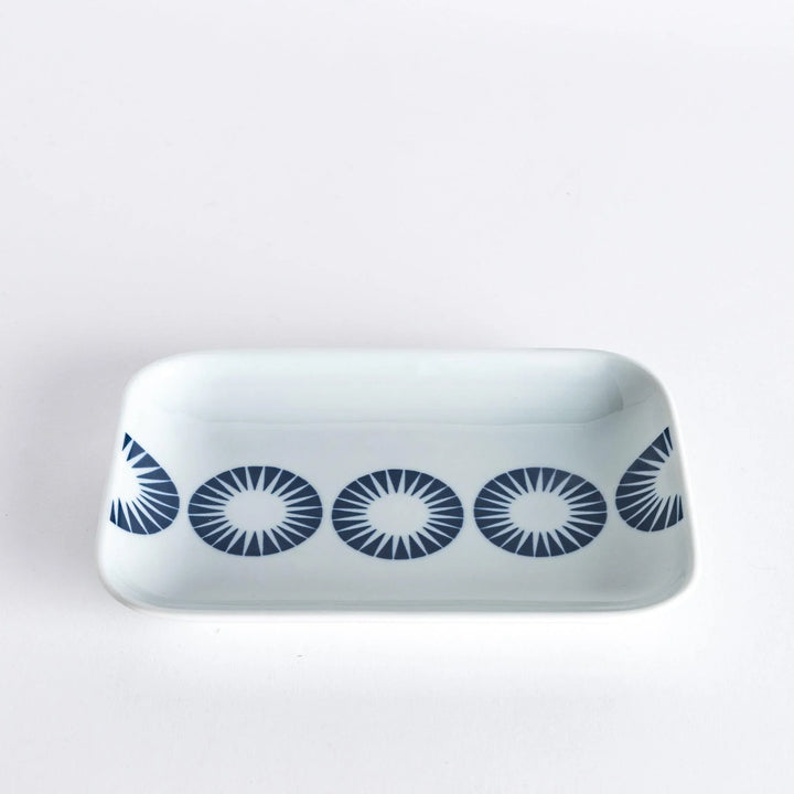 Side view of the dessert plate with the blue starburst circle pattern visible across the surface.