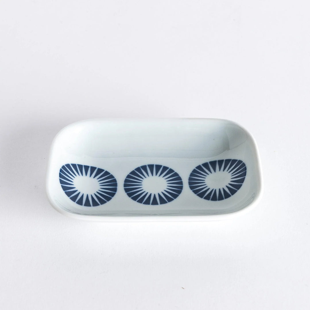 Modern Indigo Circle sauce dish with navy blue radiating pattern on white porcelain for elegant dining.