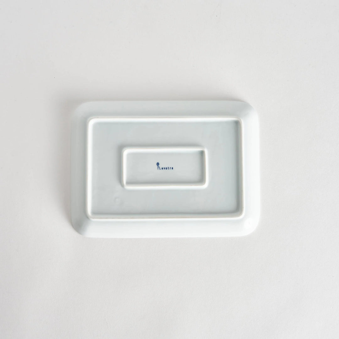 Bottom view of the Modern Indigo Lattice Dinner Plate, displaying the smooth white surface with the maker's mark visible.