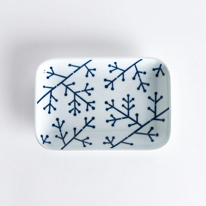 Modern Indigo Pine dessert plate with bold blue pine branch motif on white porcelain for elegant dining.