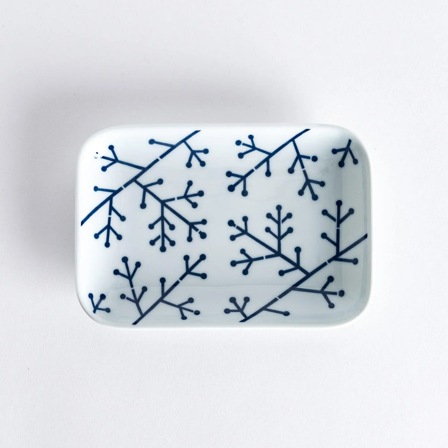 Modern Indigo Pine dessert plate with bold blue pine branch motif on white porcelain for elegant dining.