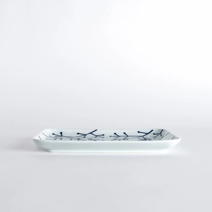 Side view of the Modern Indigo Pine Dinner Plate, featuring the detailed navy blue pine branch design along the rim.