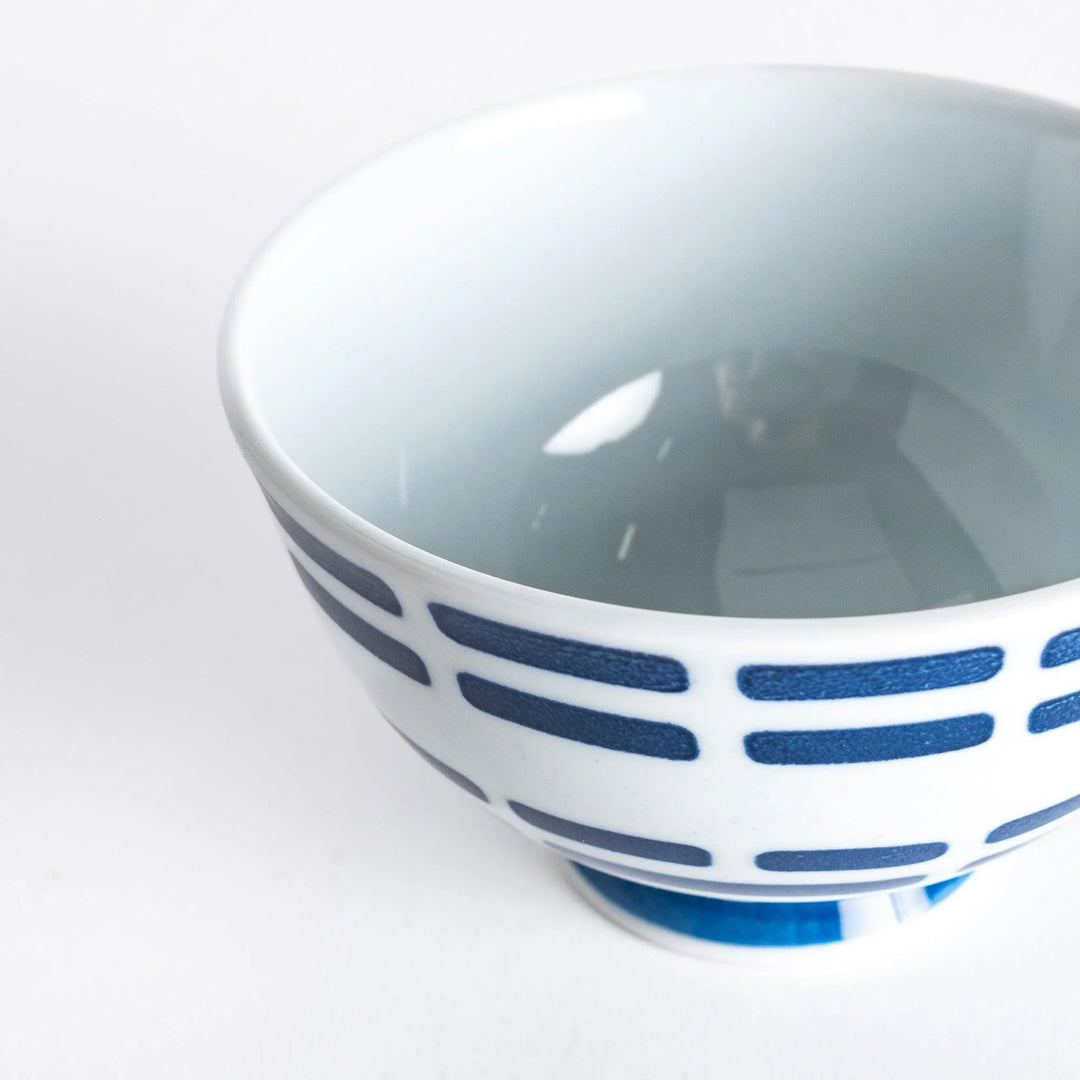 Close-up of the rice bowl with navy blue horizontal lines, taken from a slightly tilted upper angle.