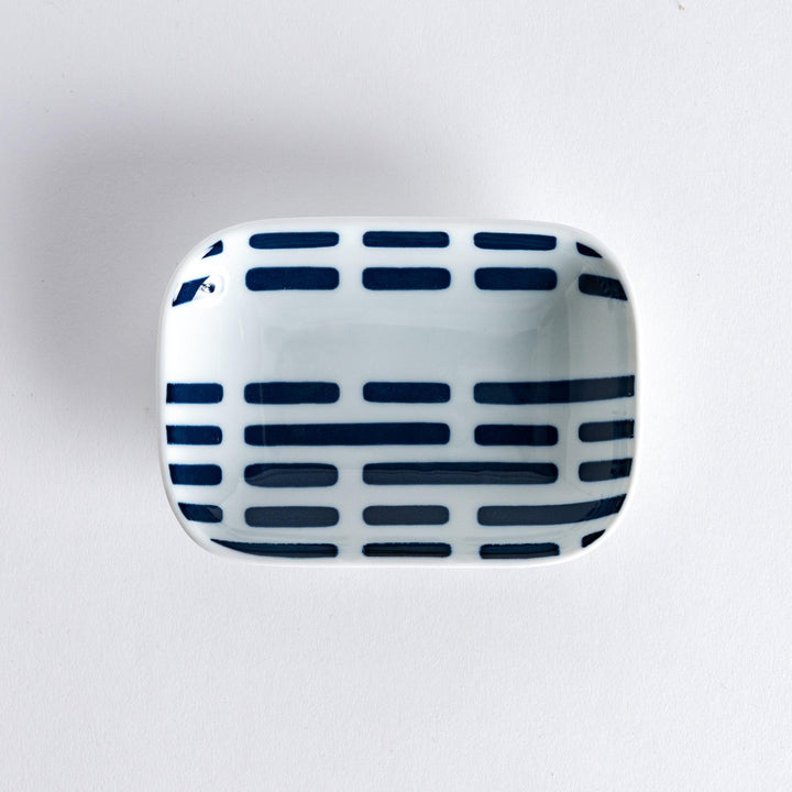 Modern Indigo River rectangular sauce dish with blue striped pattern on white porcelain shot from above.