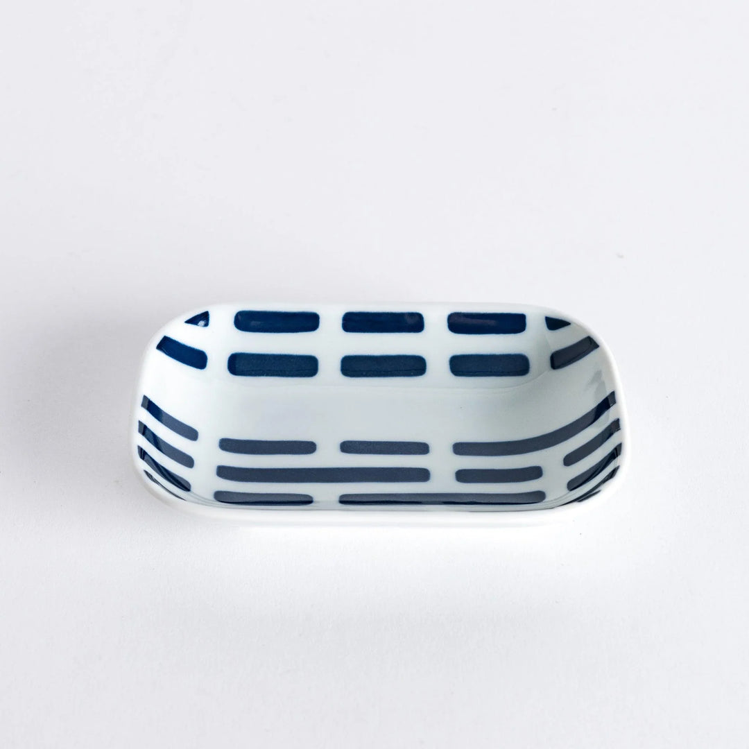 A slightly angled view of the Modern Indigo River Sauce Dish with blue striped patterns.