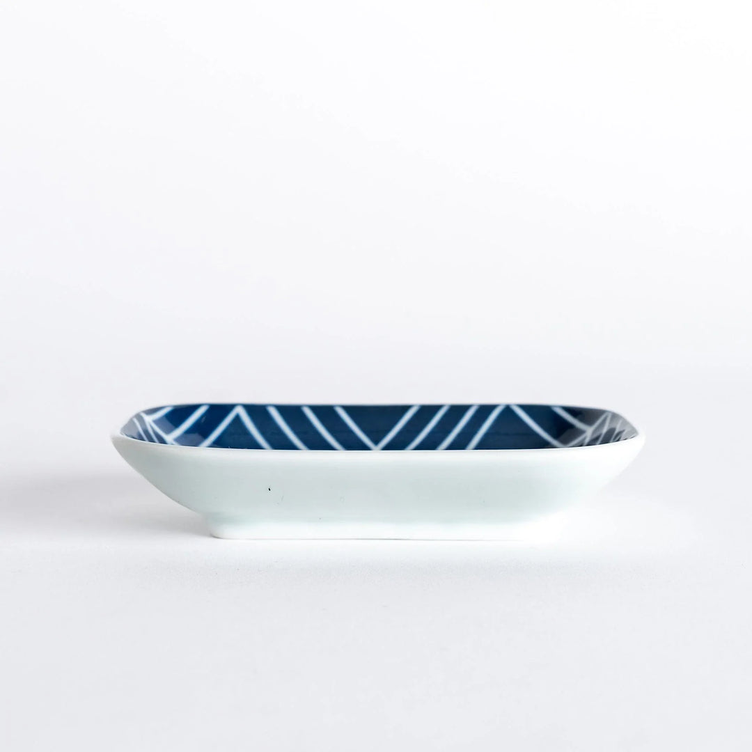 Side view of sauce dish, highlighting its rectangular shape and modern navy blue geometric pattern.