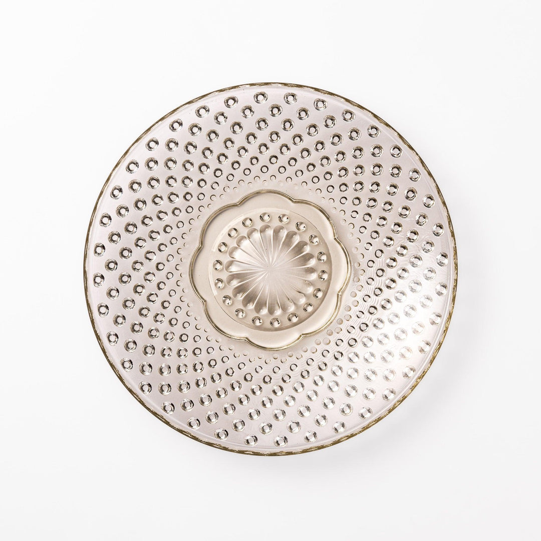 Amber glass dessert bowl and saucer with raised dots and starburst base, perfect for serving refined sweets.