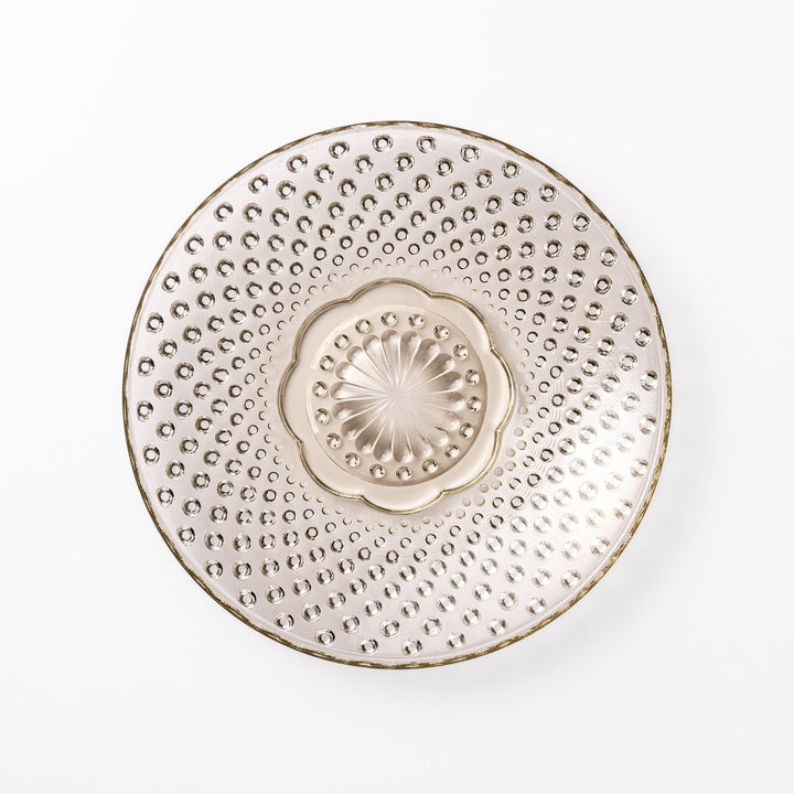 Amber glass dessert bowl and saucer with raised dots and starburst base, perfect for serving refined sweets.