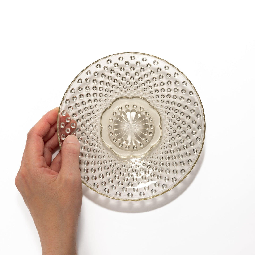 Amber glass dessert bowl and saucer with raised dots and starburst base, perfect for serving refined sweets.