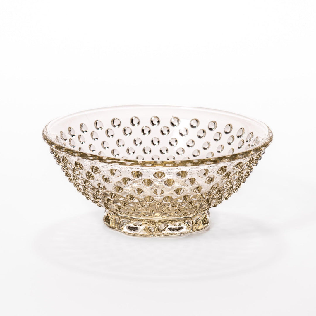 Amber glass dessert bowl and saucer with raised dots and starburst base, perfect for serving refined sweets.