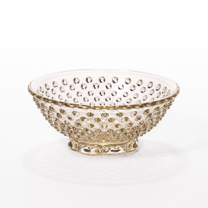 Amber glass dessert bowl and saucer with raised dots and starburst base, perfect for serving refined sweets.