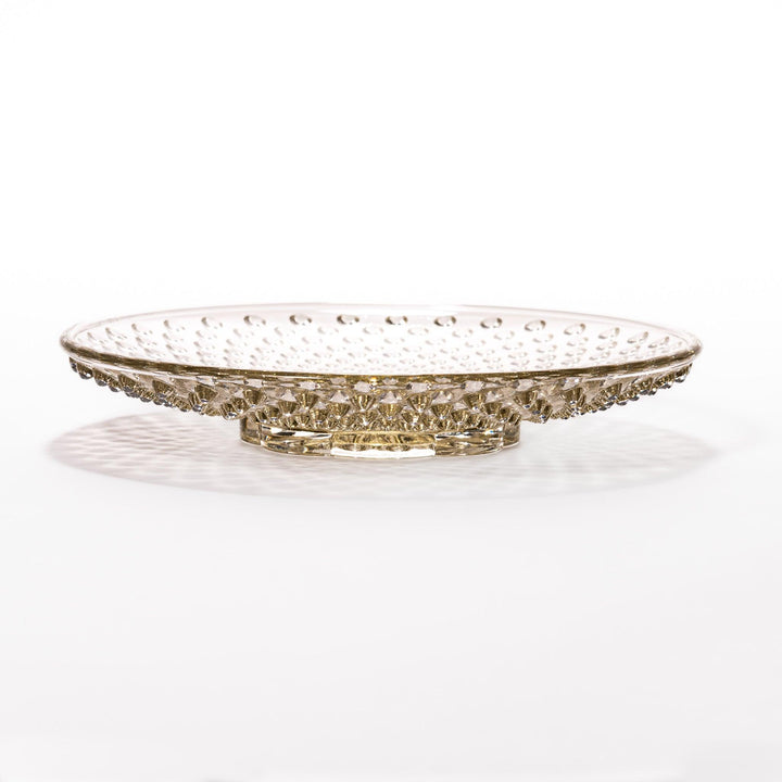Amber glass dessert bowl and saucer with raised dots and starburst base, perfect for serving refined sweets.