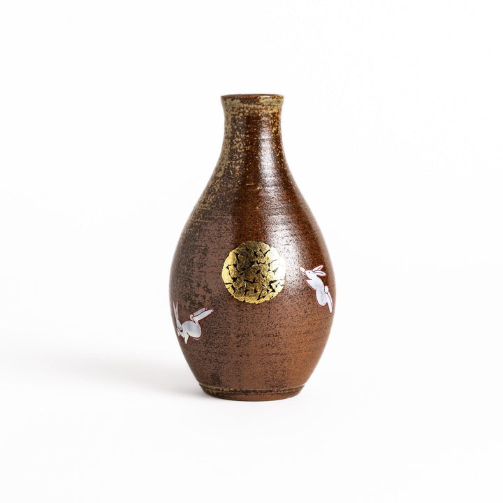 Brown ceramic sake set with rabbit and moon design including carafe and cups on tray for sharing.