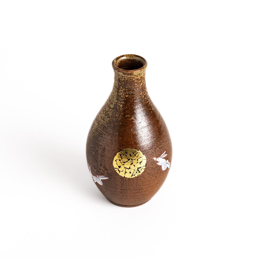 Brown ceramic sake set with rabbit and moon design including carafe and cups on tray for sharing.