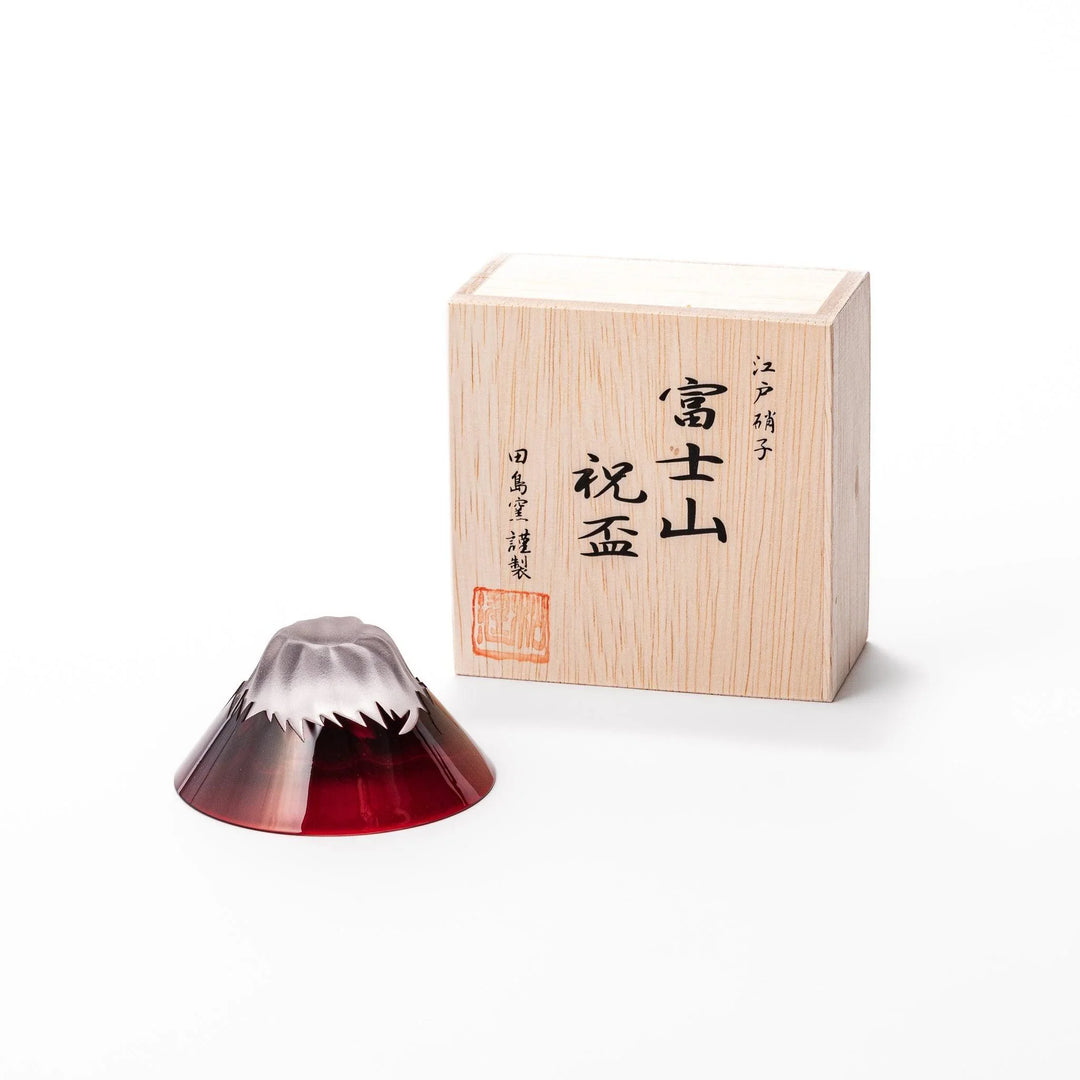 Red glass sake cup shaped like Mount Fuji with a frosted snowcap, ideal for elegant Japanese-style celebrations.