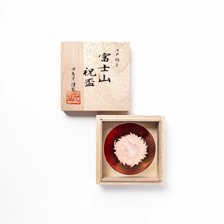 Red glass sake cup shaped like Mount Fuji with a frosted snowcap, ideal for elegant Japanese-style celebrations.
