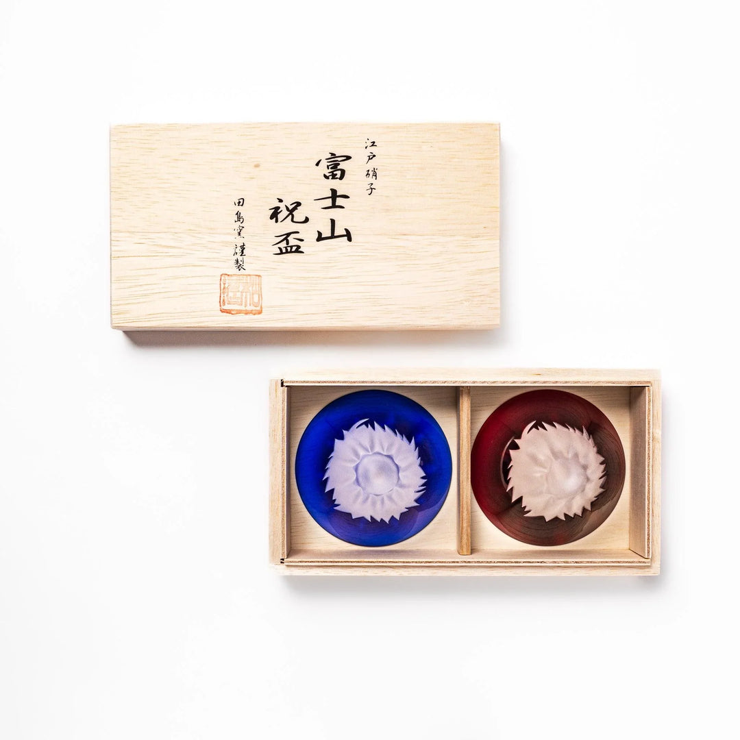 Mount Fuji sake cups in red and blue glass with frosted snowcaps, perfect for festive toasts or gifting.