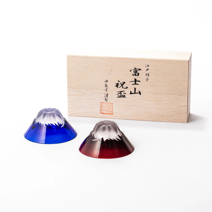 Mount Fuji sake cups in red and blue glass with frosted snowcaps, perfect for festive toasts or gifting.