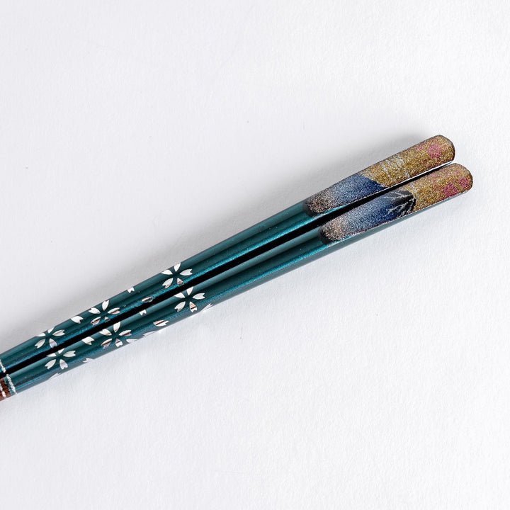 A boxed set of two pairs of chopsticks, one with blue and one with red handles, featuring Mount Fuji designs.