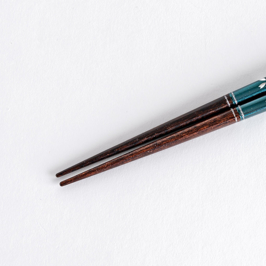 A boxed set of two pairs of chopsticks, one with blue and one with red handles, featuring Mount Fuji designs.