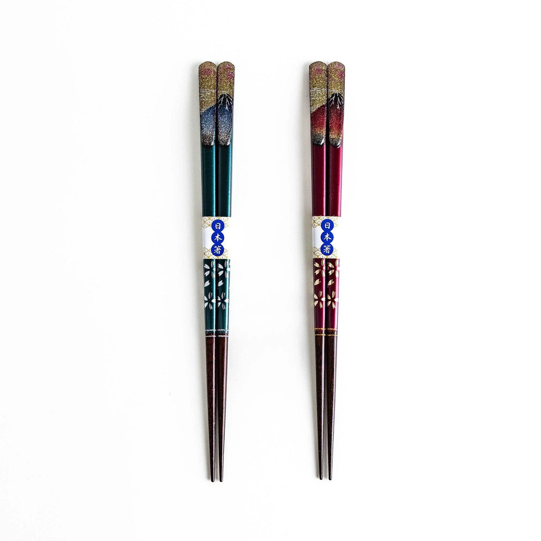 A boxed set of two pairs of chopsticks, one with blue and one with red handles, featuring Mount Fuji designs.