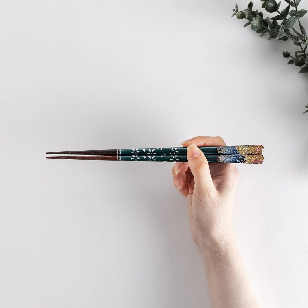 A boxed set of two pairs of chopsticks, one with blue and one with red handles, featuring Mount Fuji designs.