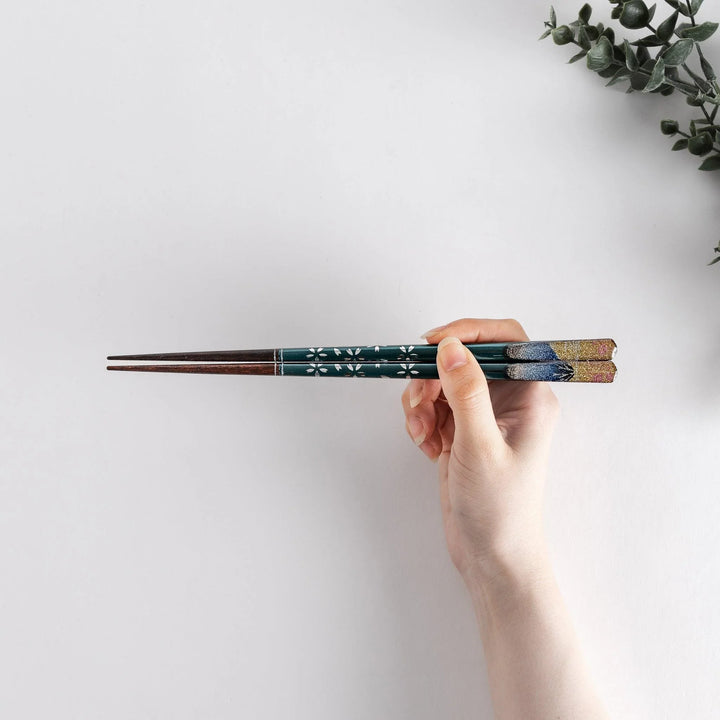 A boxed set of two pairs of chopsticks, one with blue and one with red handles, featuring Mount Fuji designs.