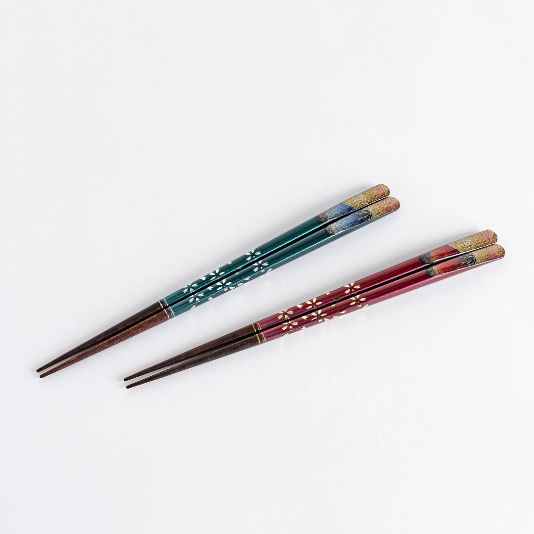 A boxed set of two pairs of chopsticks, one with blue and one with red handles, featuring Mount Fuji designs.