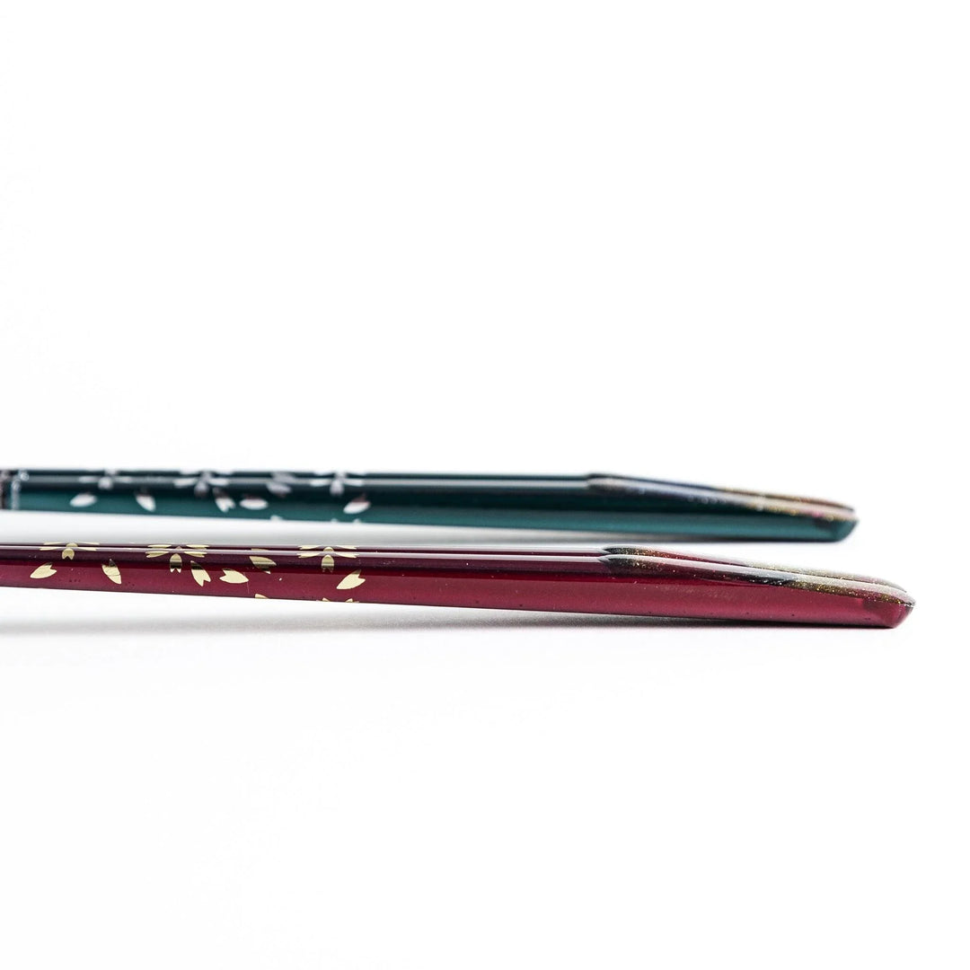 A boxed set of two pairs of chopsticks, one with blue and one with red handles, featuring Mount Fuji designs.