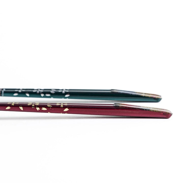 A boxed set of two pairs of chopsticks, one with blue and one with red handles, featuring Mount Fuji designs.