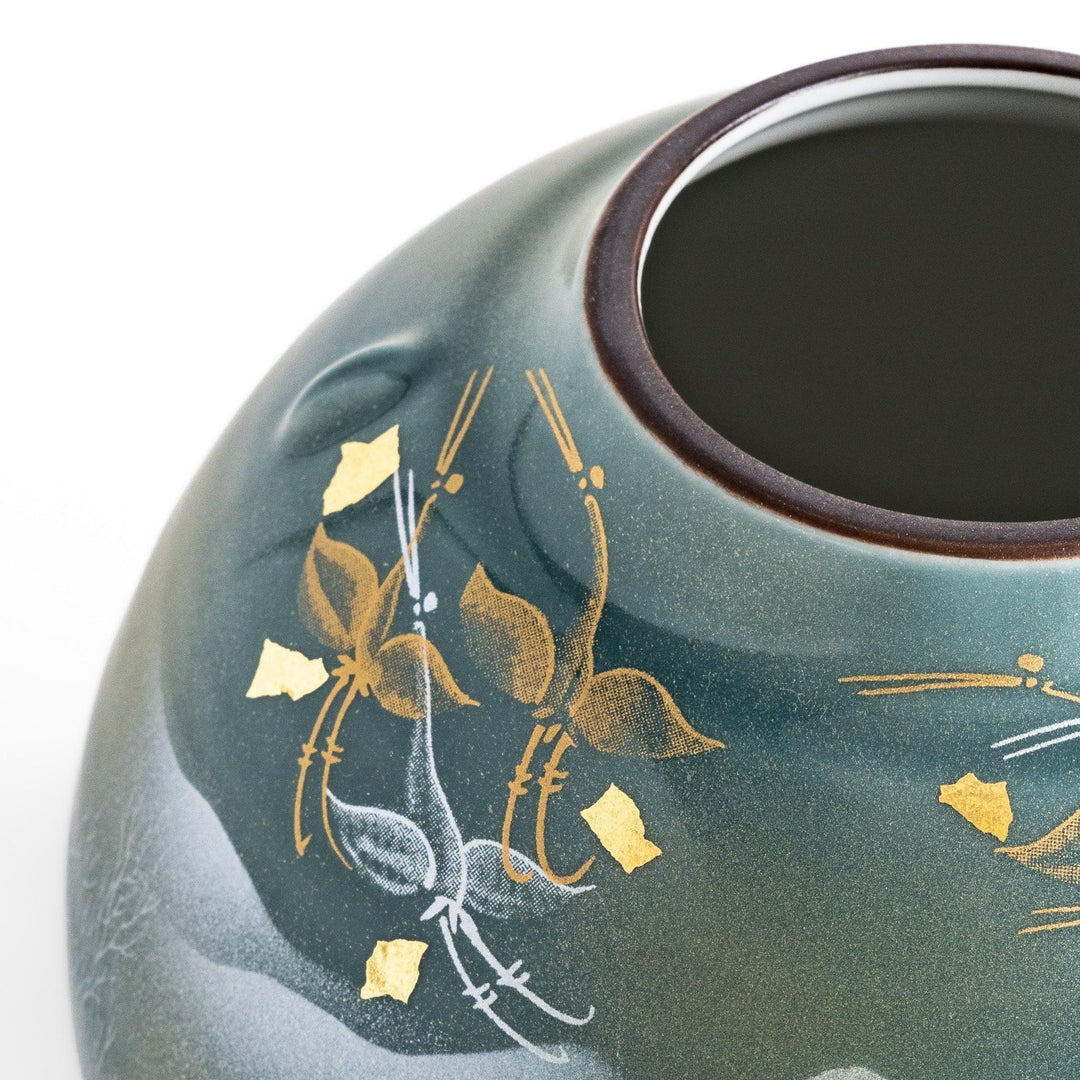 Handcrafted vase with serene mountain scene gold leaf accents and delicate trees in soft teal tones.