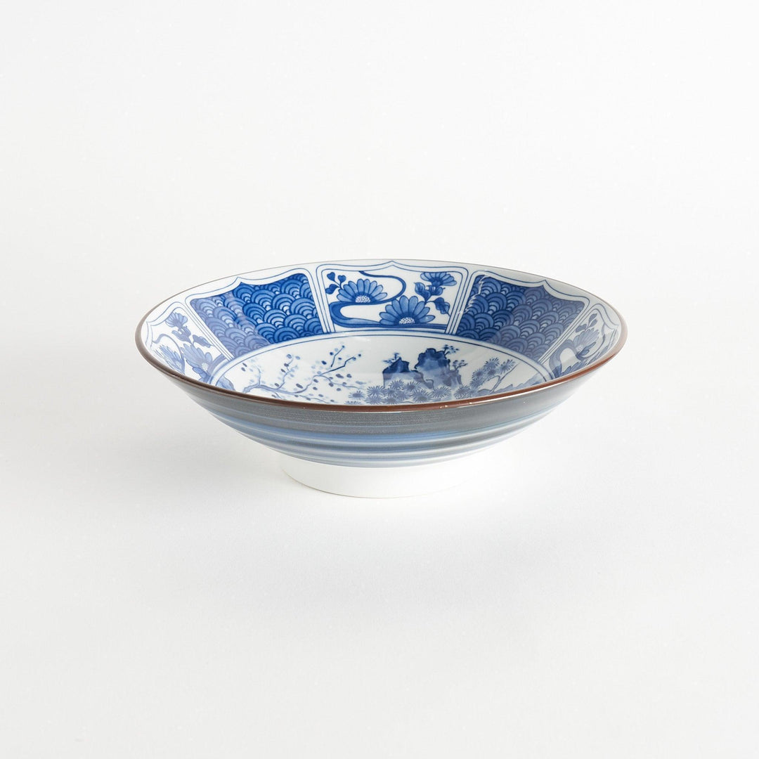 Bowl with dark blue exterior and white interior featuring blue floral wave and landscape motifs inside.