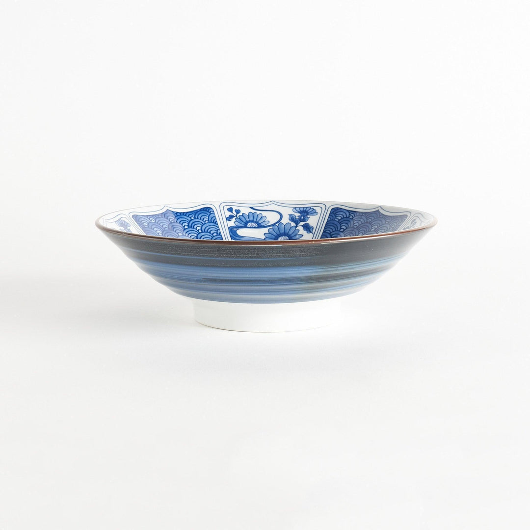 Bowl with dark blue exterior and white interior featuring blue floral wave and landscape motifs inside.
