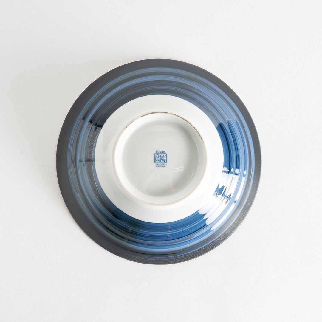 Bowl with dark blue exterior and white interior featuring blue floral wave and landscape motifs inside.