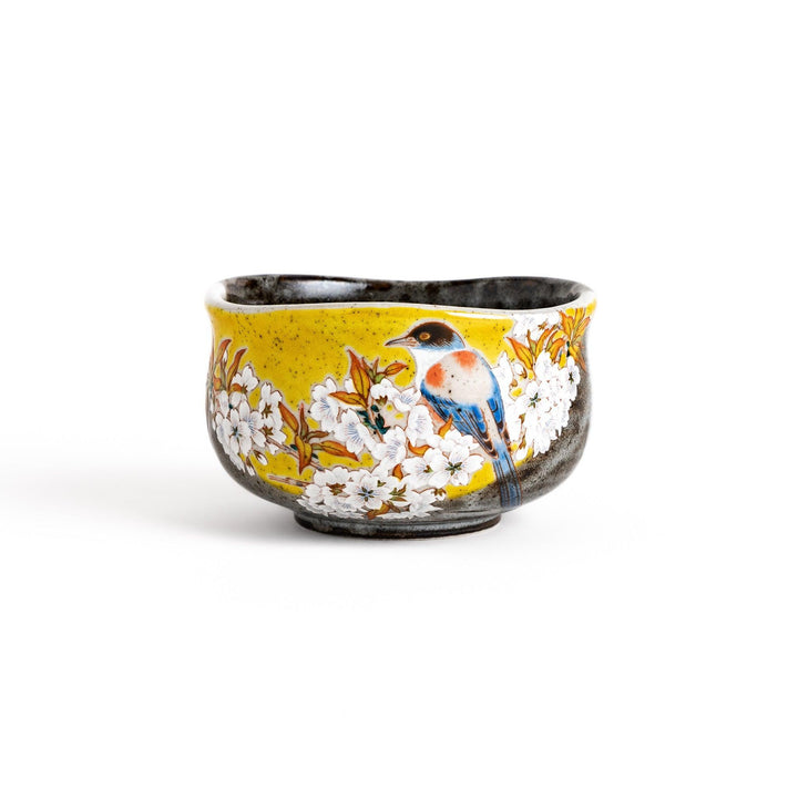 Yellow matcha bowl with bird and flowering branch design ideal for preparing and enjoying matcha tea.