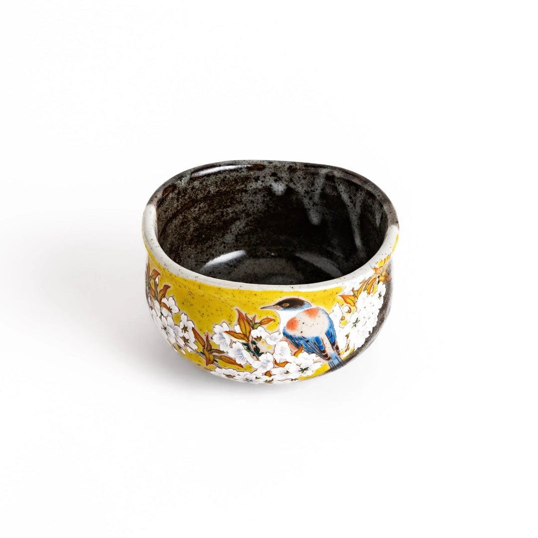 Yellow matcha bowl with bird and flowering branch design ideal for preparing and enjoying matcha tea.