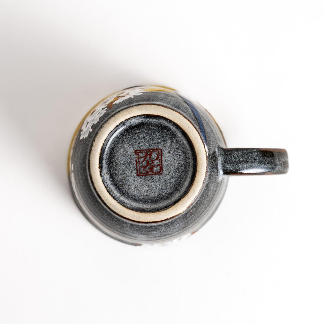 Ceramic mug with bird and flowering branch on yellow background perfect for daily coffee or tea.