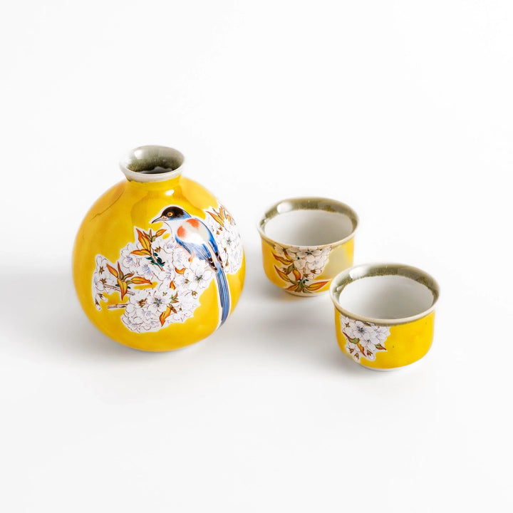 Yellow sake set with bird and cherry blossom floral design including bottle and cups for spring dining.