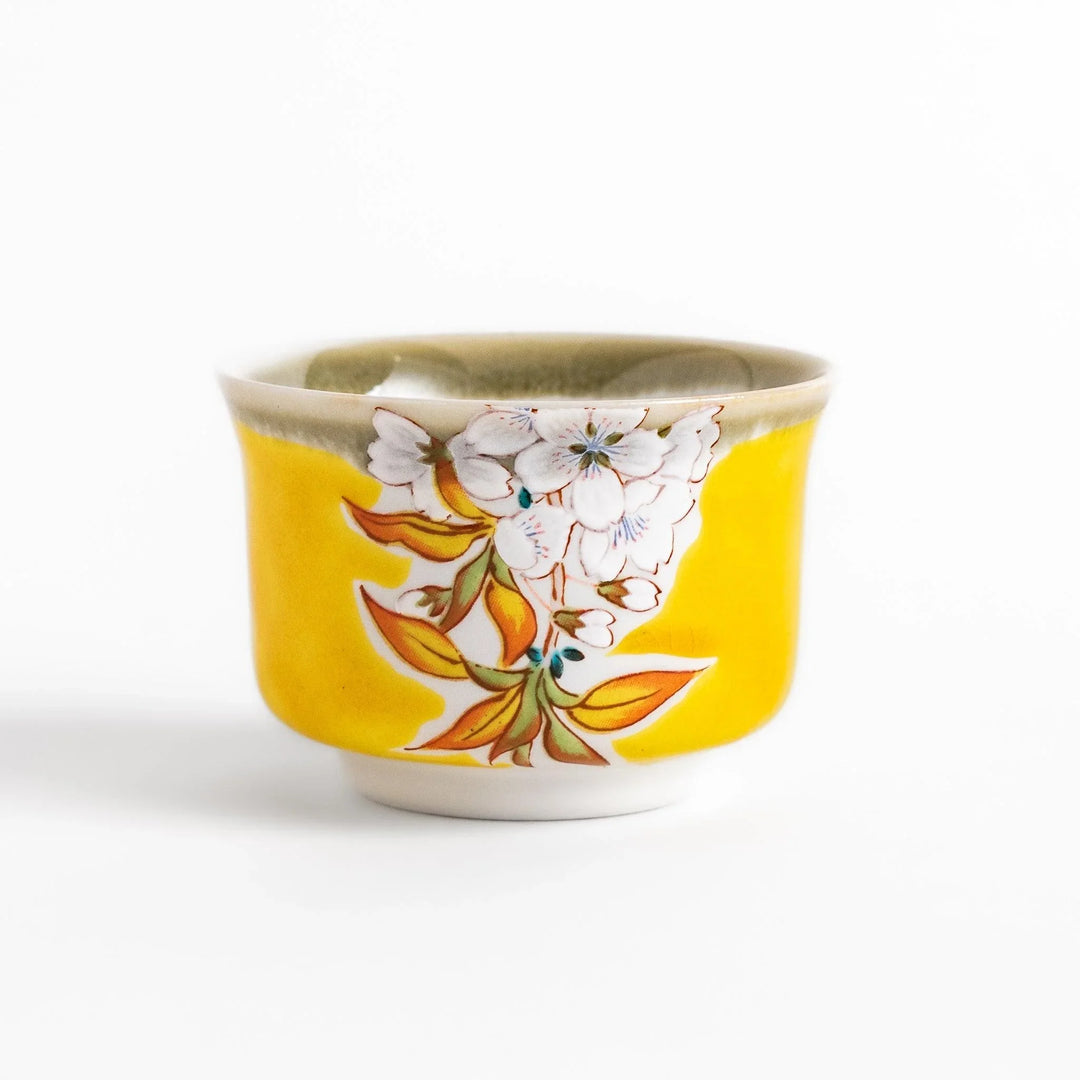 Yellow sake set with bird and cherry blossom floral design including bottle and cups for spring dining.