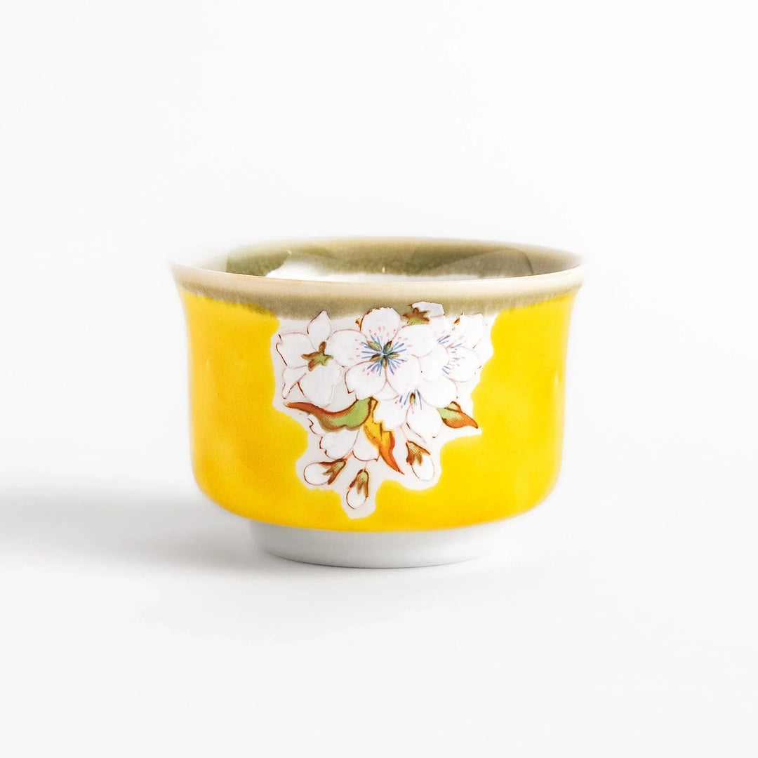 Yellow sake set with bird and cherry blossom floral design including bottle and cups for spring dining.
