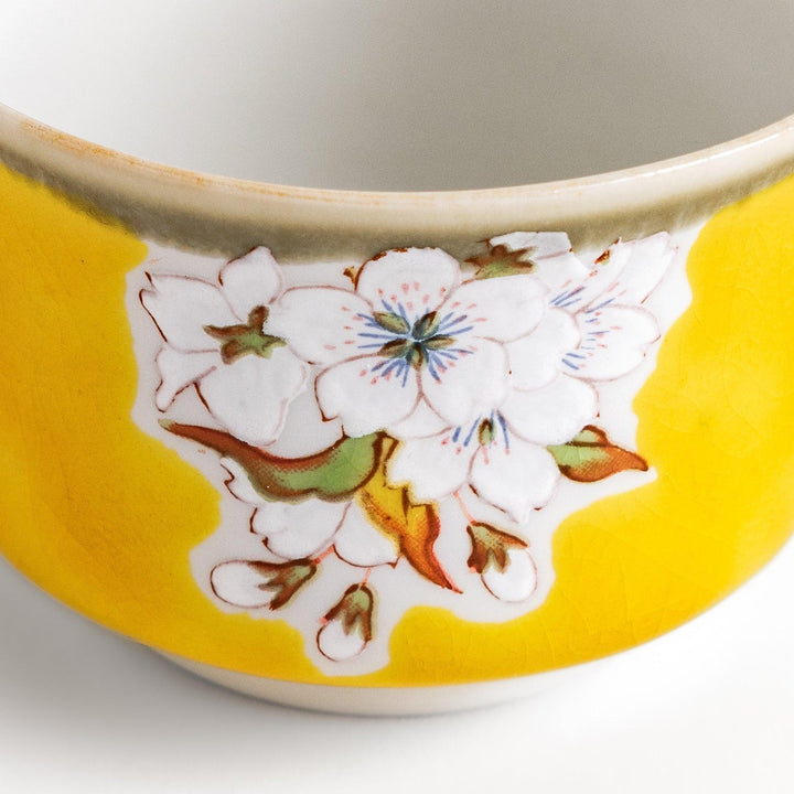 Yellow sake set with bird and cherry blossom floral design including bottle and cups for spring dining.