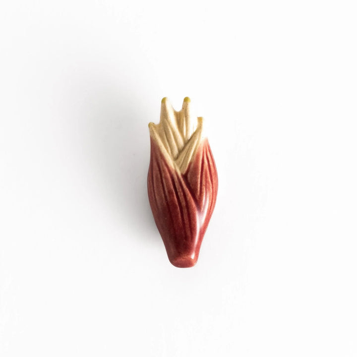 Glossy ceramic myoga ginger-shaped chopstick rest in soft red with beige tones, elegantly crafted for a unique table setting.