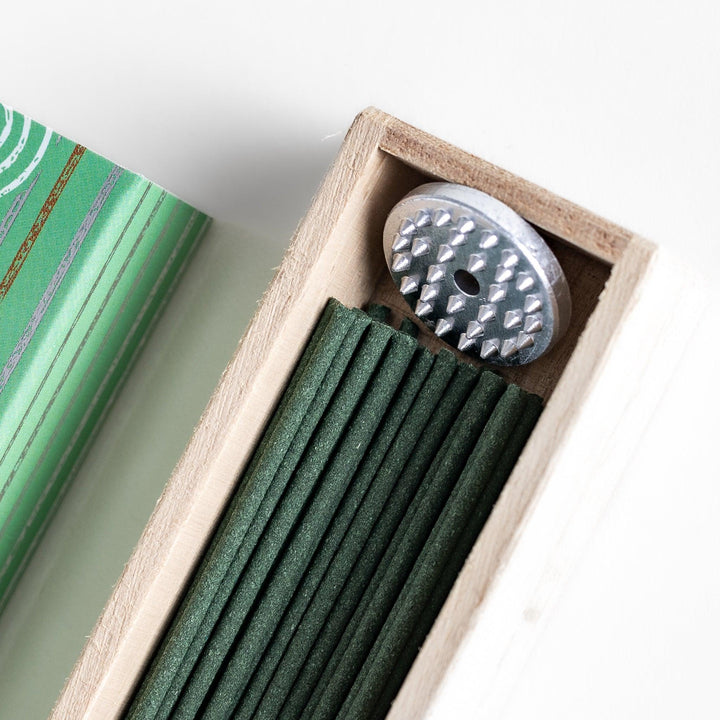 Japanese camphor tree incense sticks in a wooden box with a green patterned sleeve from Kyoto’s Kousaido